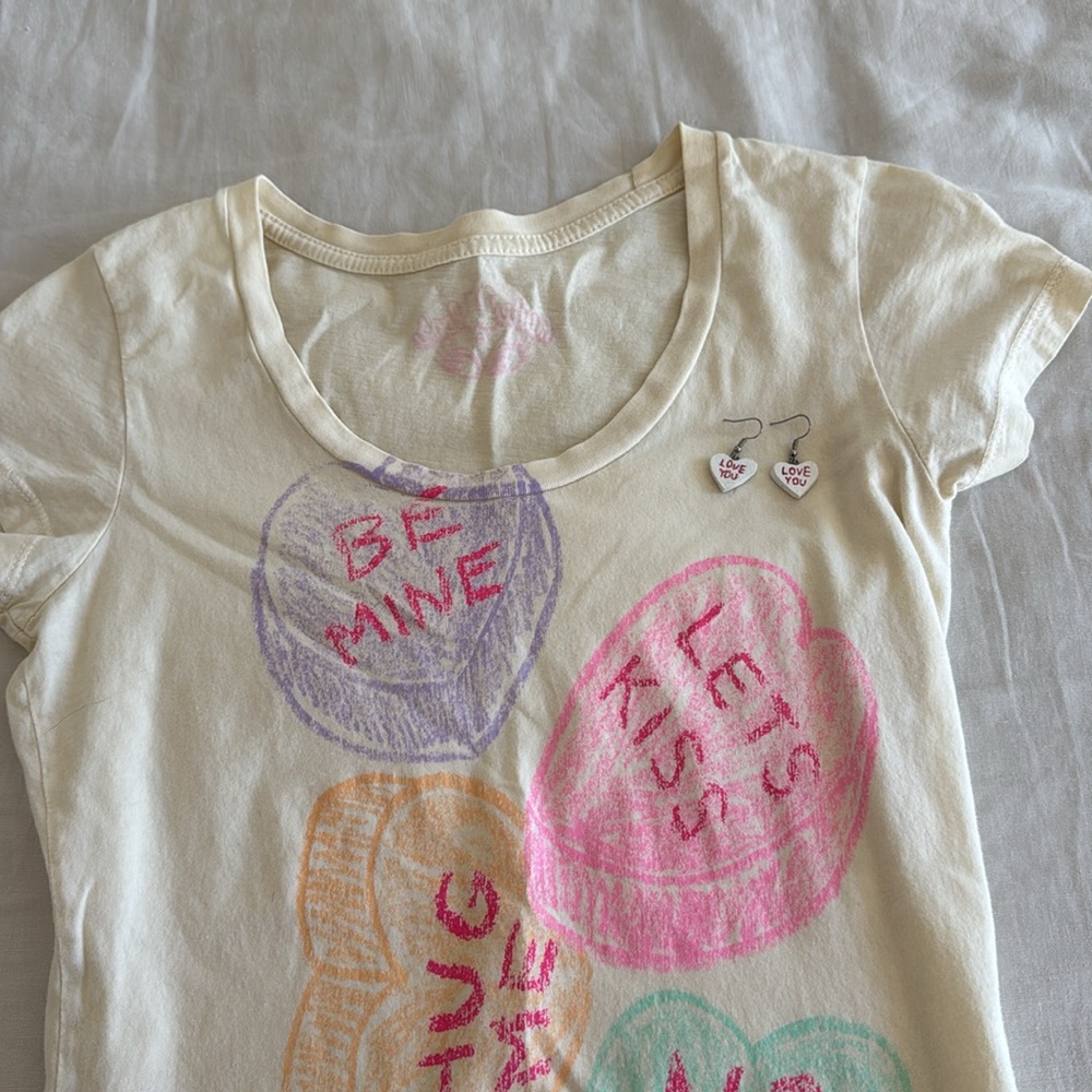 made U look 👀 T-shirt and conversation heart ♥️ earrings.